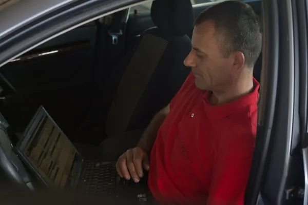 Mecanic Concept Auto făcând diagnoza computerizată a unui autoturism